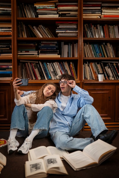 Foto gratuita pareja de tiro completo que tiene una cita en la librería