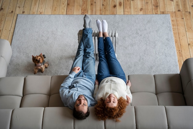 Pareja de tiro completo sentada en el sofá