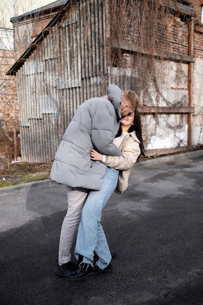 Pareja de tiro completo siendo romántica al aire libre