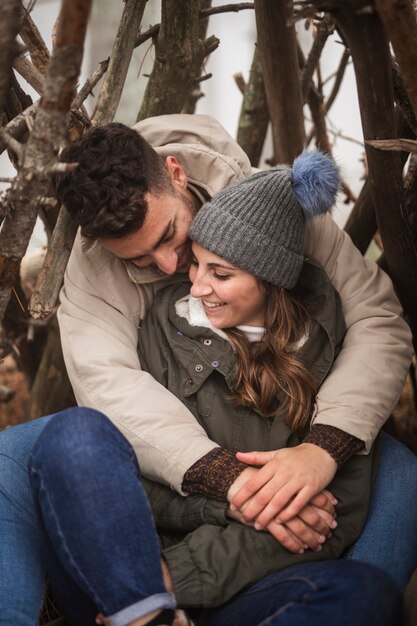 Pareja de tiro completo siendo romántico en la naturaleza