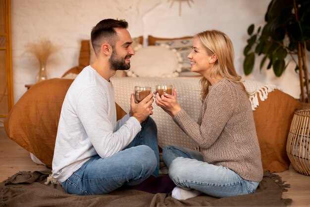 Pareja de tiro completo sosteniendo bebidas