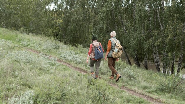 Pareja de tiro largo caminando por un sendero