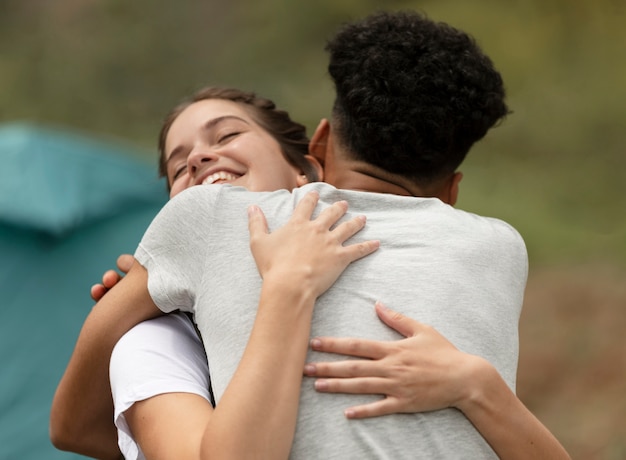 Foto gratuita pareja de tiro medio abrazándose al aire libre