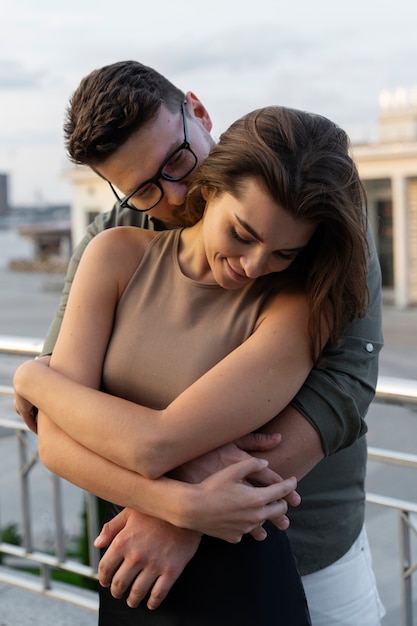 Pareja de tiro medio abrazándose al aire libre