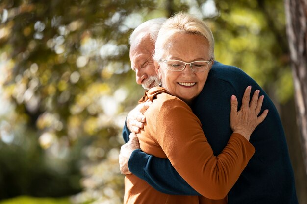 Pareja de tiro medio abrazándose fuera