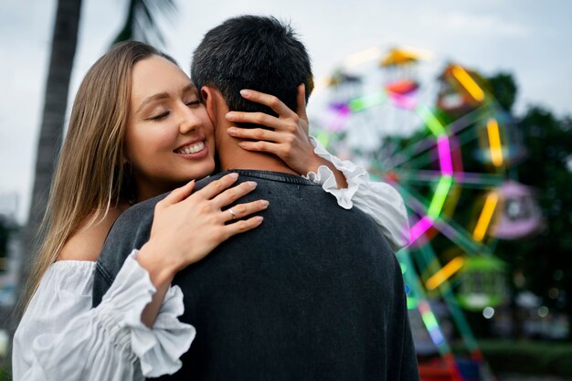 Pareja de tiro medio abrazándose en el parque de atracciones