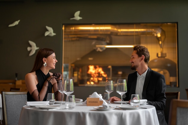 Pareja de tiro medio almorzando en un restaurante de lujo