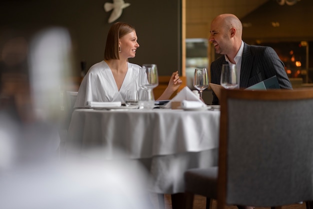 Pareja de tiro medio almorzando en un restaurante de lujo