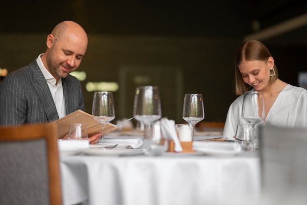 Pareja de tiro medio almorzando en un restaurante de lujo