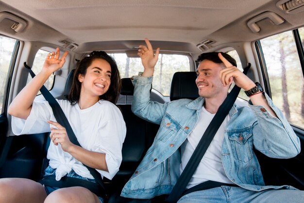 Pareja de tiro medio bailando dentro del coche