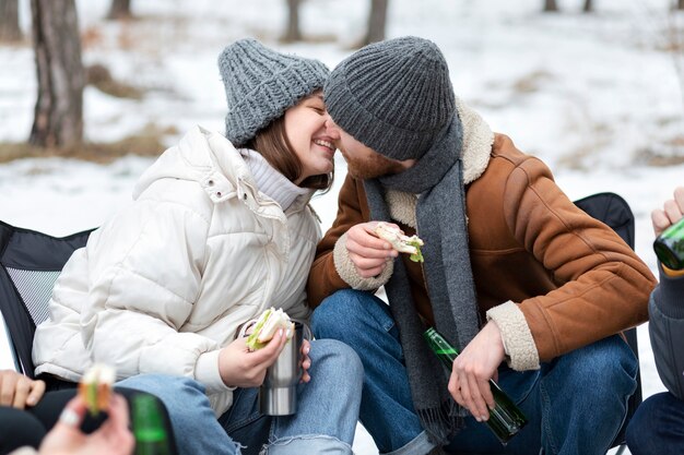 Pareja de tiro medio besándose en la naturaleza