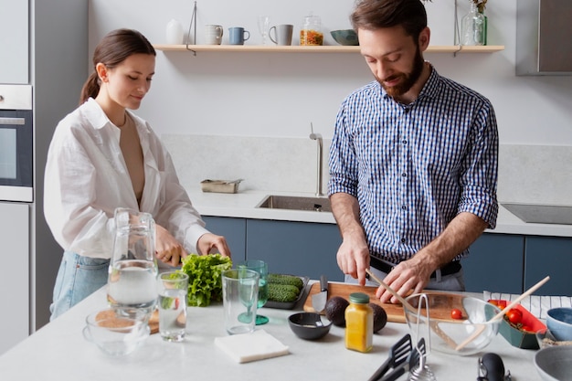 Pareja de tiro medio cocinando en casa