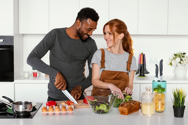 Pareja de tiro medio cocinando juntos