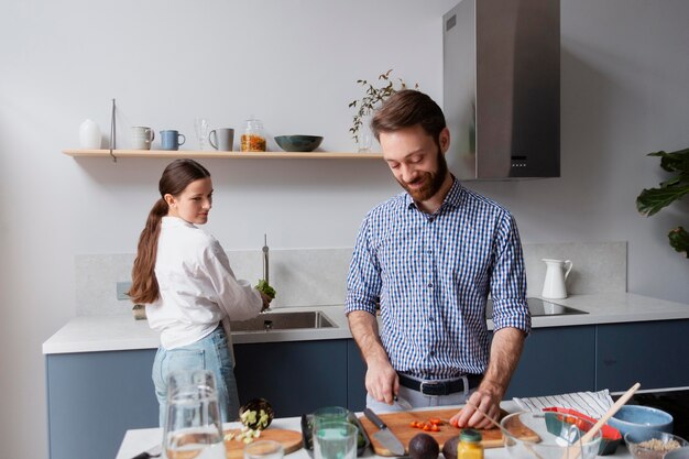 Pareja de tiro medio cocinando juntos