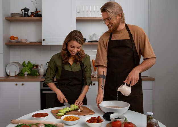 Pareja de tiro medio cocinando juntos