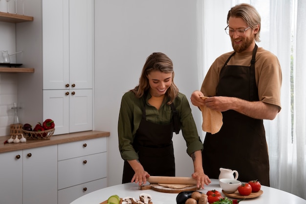 Pareja de tiro medio cocinando juntos