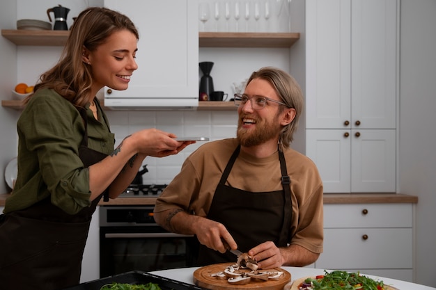 Foto gratuita pareja de tiro medio cocinando juntos