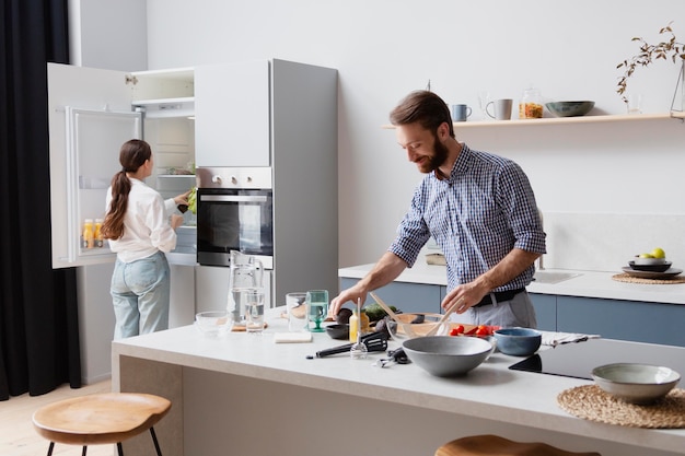 Pareja de tiro medio cocinar en la cocina