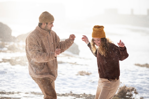 Foto gratuita pareja de tiro medio divirtiéndose con la nieve