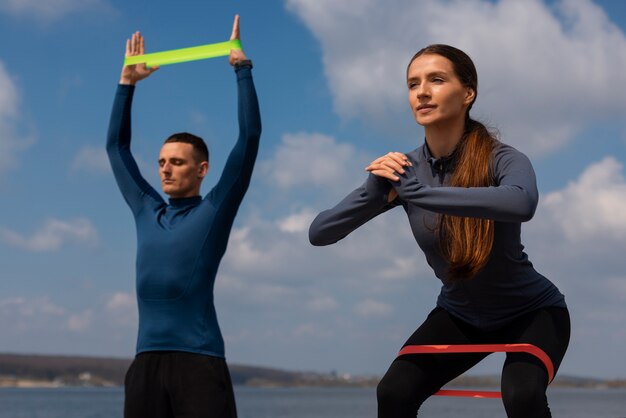 Pareja de tiro medio entrenando juntos al aire libre