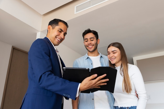 Foto gratuita pareja de tiro medio hablando con agente inmobiliario