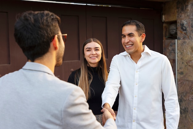 Foto gratuita pareja de tiro medio hablando con agente inmobiliario