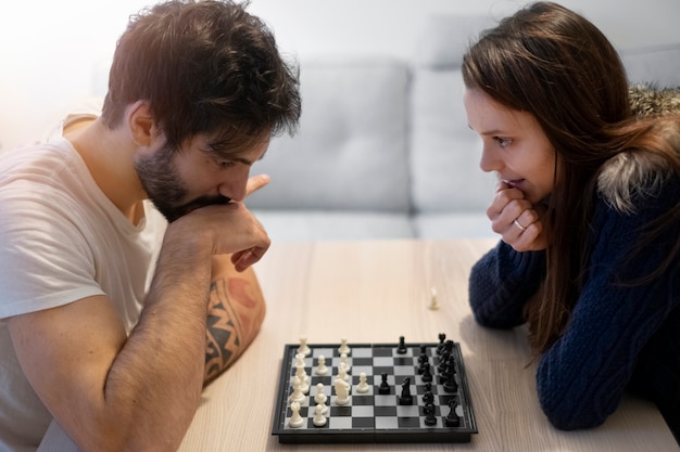 Pareja de tiro medio jugando al ajedrez