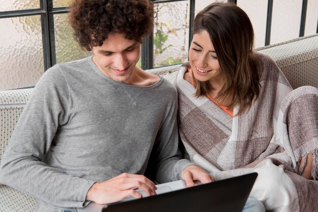 Foto gratuita pareja de tiro medio con laptop