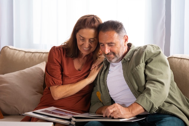 Foto gratuita pareja de tiro medio mirando álbum de fotos