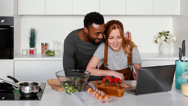 Foto gratuita pareja de tiro medio mirando portátil