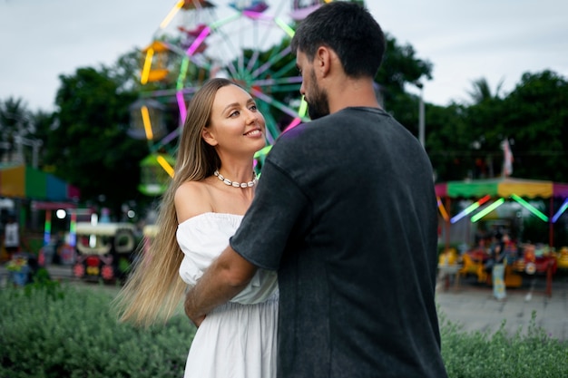 Pareja de tiro medio en el parque de atracciones