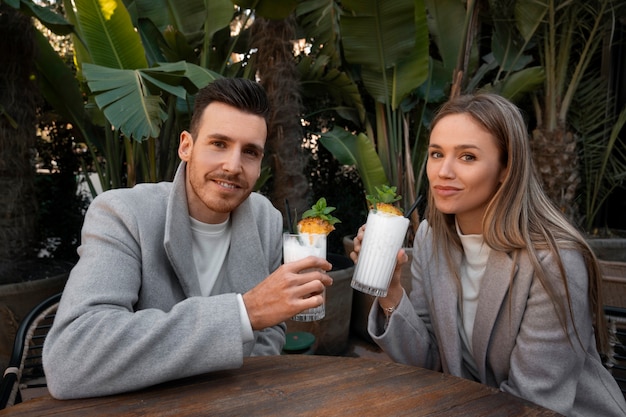 Foto gratuita pareja de tiro medio con piña colada