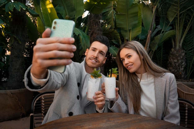 Foto gratuita pareja de tiro medio con piña colada