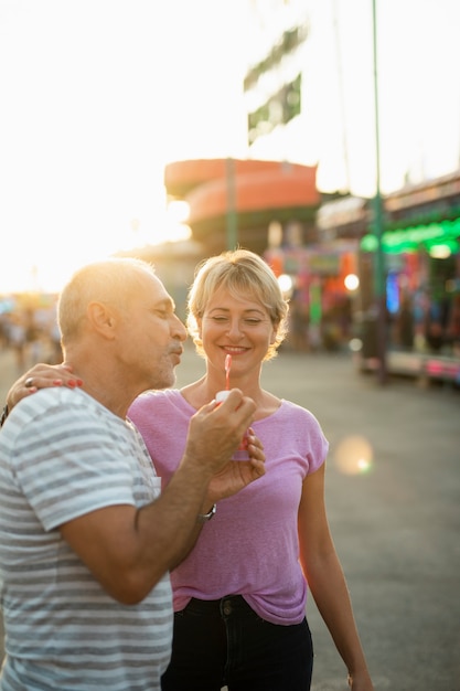 Foto gratuita pareja de tiro medio con pompas de jabón