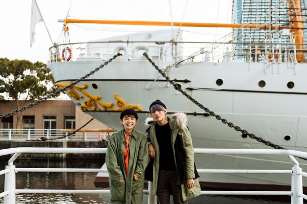 Pareja de tiro medio posando con barco