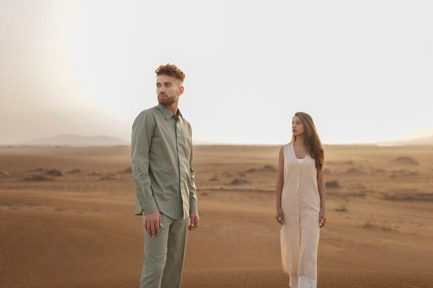 Pareja de tiro medio posando en el desierto