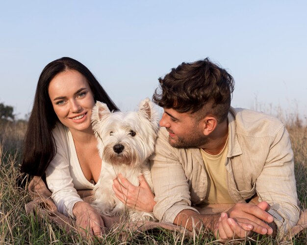 Pareja de tiro medio posando con perro