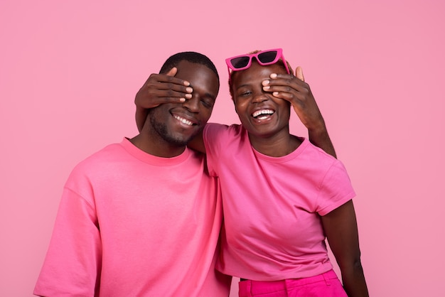 Pareja de tiro medio posando con traje rosa