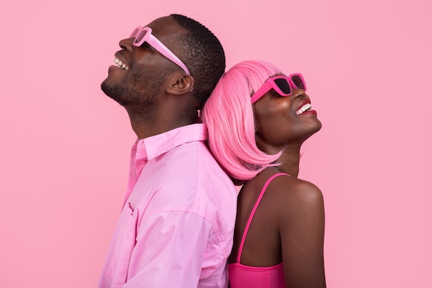 Foto gratuita pareja de tiro medio posando con traje rosa