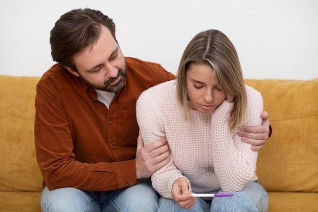 Foto gratuita pareja de tiro medio con prueba de embarazo.