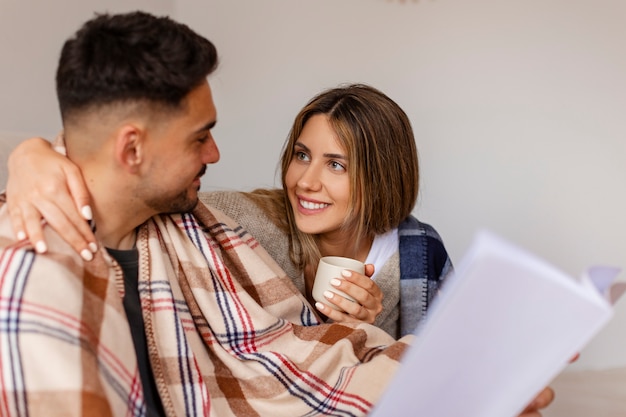 Pareja de tiro medio siendo cariñosa en el interior