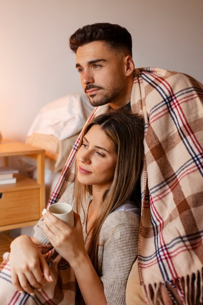 Pareja de tiro medio siendo cariñosa en el interior