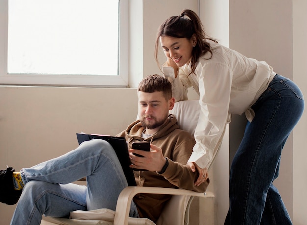 Foto gratuita pareja de tiro medio con smartphone