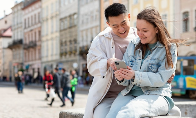 Foto gratuita pareja con tiro medio de smartphone