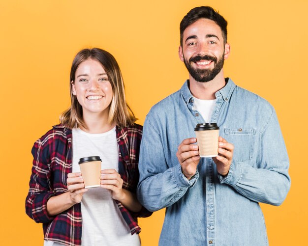 Pareja de tiro medio sosteniendo tazas de café