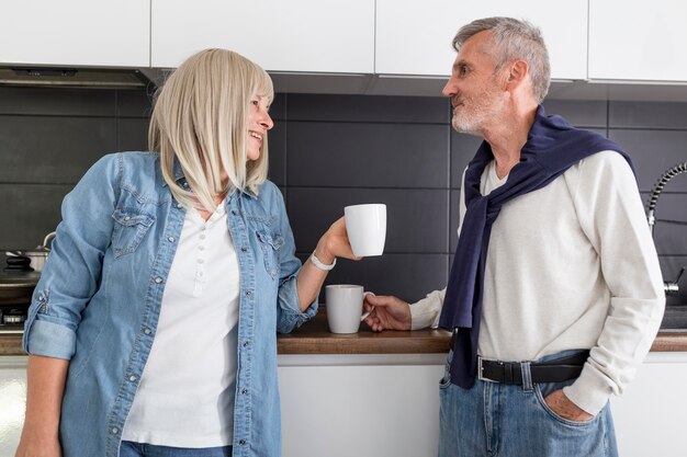 Foto gratuita pareja de tiro medio sosteniendo tazas