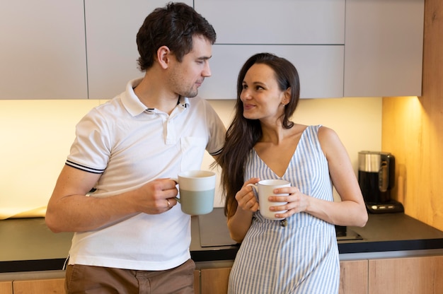 Foto gratuita pareja de tiro medio con tazas de café