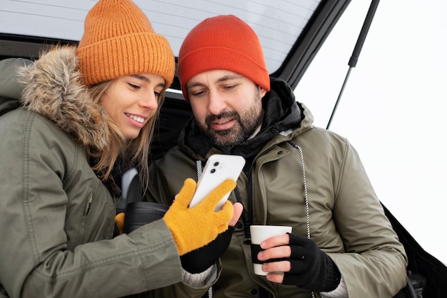 Pareja de tiro medio con teléfono inteligente