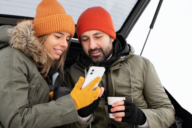 Pareja de tiro medio con teléfono inteligente