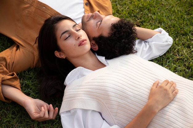 Foto gratuita pareja de tiro medio tendido sobre el césped